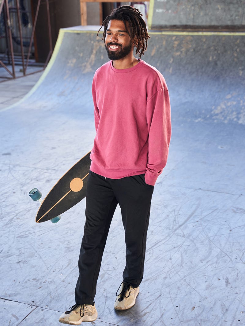Men's outfit idea for 2022 with pink plain sweatshirt, black trackpants, neutral sneakers. Suitable for spring, summer and fall.