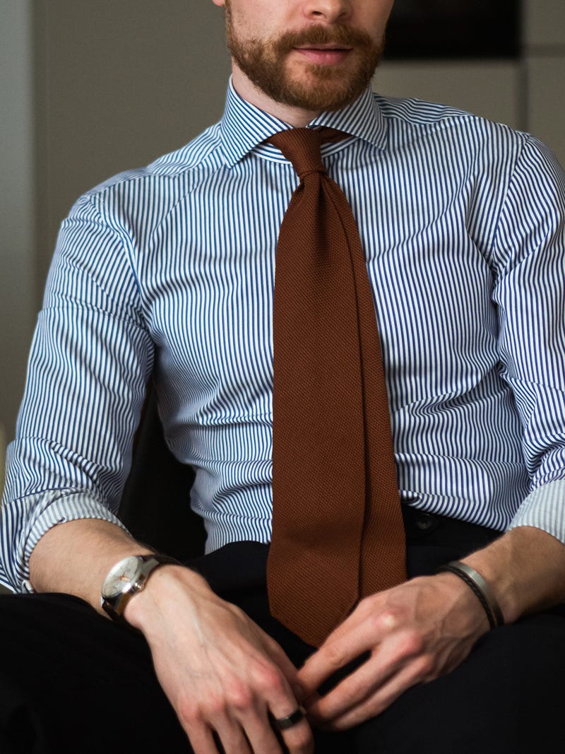Men's outfit idea for 2022 with blue striped dress shirt, navy dress pants, red plain tie, brown leather strap watch, oxford / derby shoes. Suitable for spring and fall.