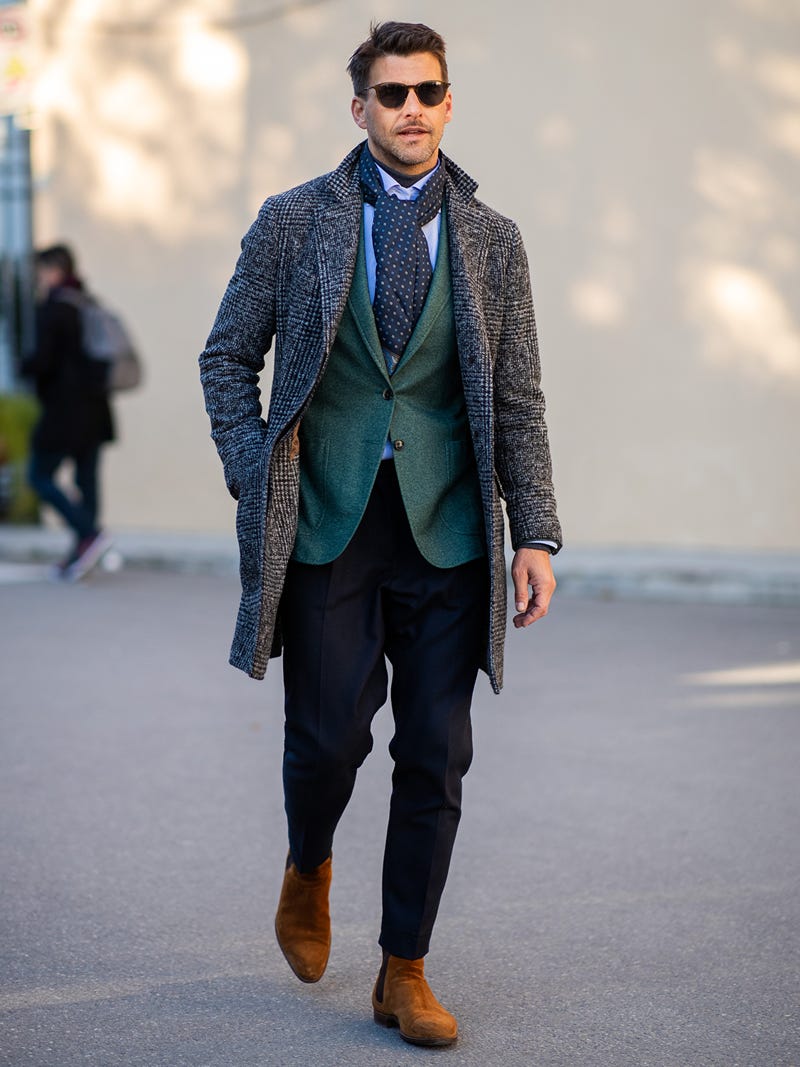 Men's outfit idea for 2022 with grey single-breasted overcoat, green blazer, blue dress shirt, navy dress pants, brown chelsea boots. Suitable for fall and winter.