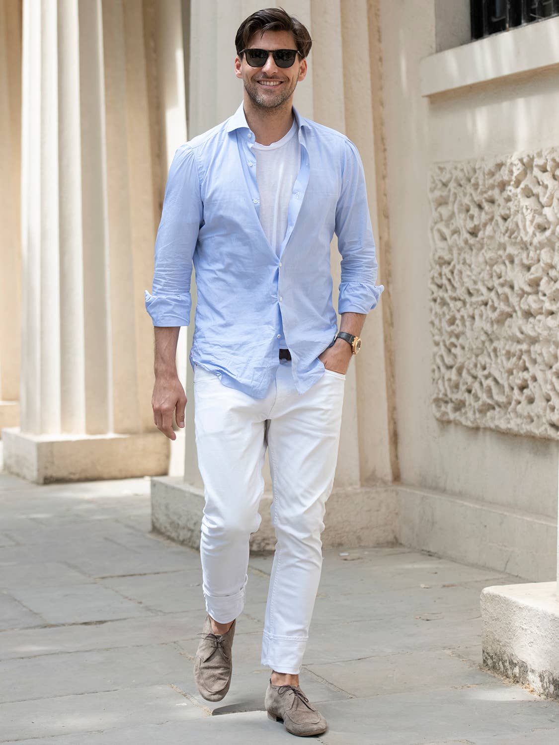 Men's outfit idea for 2022 with blue linen shirt, white crew neck t-shirt, white jeans, black thick framed sunglasses, neutral suede shoes / desert shoes. Suitable for spring and summer.