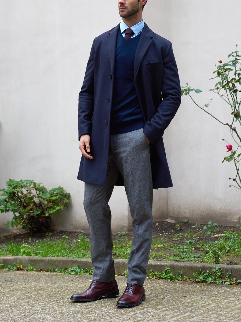 Men's outfit idea for 2022 with single-breasted overcoat, blue dress shirt, gray dress pants, bold-colored tie, brown oxford / derby shoes. Suitable for fall and winter.