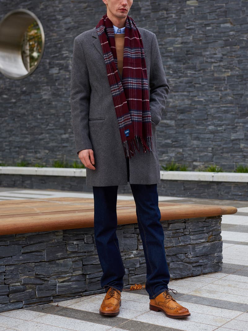 Men's outfit idea for 2022 with single-breasted overcoat, bold-colored crew neck sweater, blue dress shirt, dark blue jeans, brown brogues. Suitable for fall and winter.