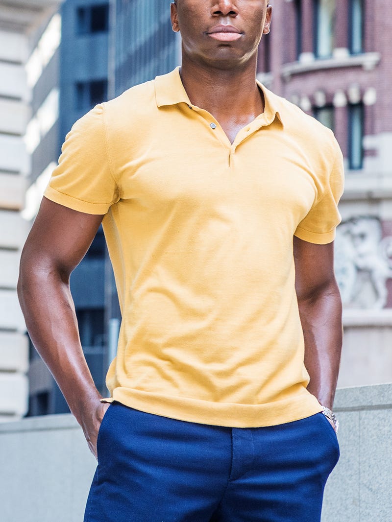 Men's outfit idea for 2022 with bold-colored polo, navy dress pants, white sneakers. Suitable for summer.