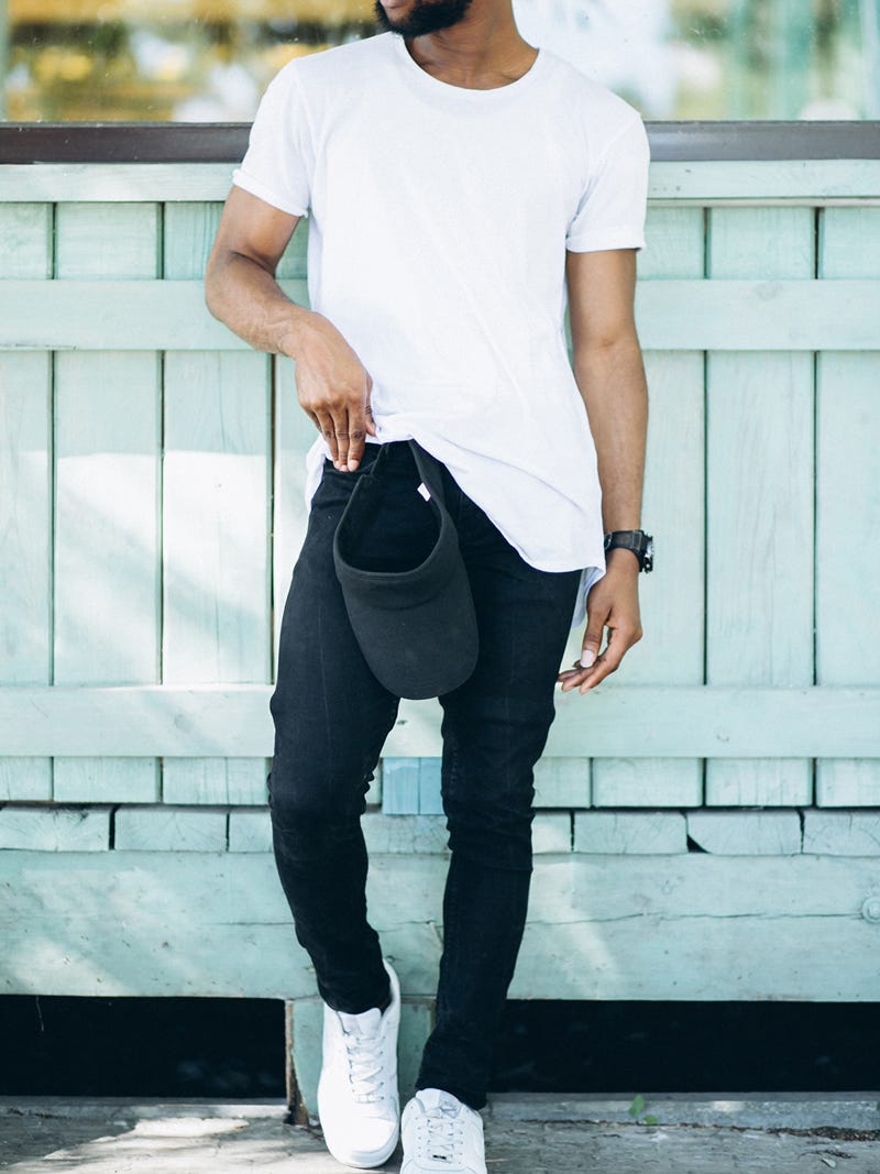 Men's outfit idea for 2022 with white crew neck t-shirt, black jeans, black canvas strap watch, white trainers. Suitable for spring, summer and autumn.