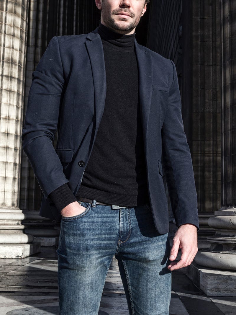 Men's outfit idea for 2022 with navy unstructured blazer, black lightweight rollneck jumper, dark blue jeans, black chelsea boots. Suitable for spring and autumn.