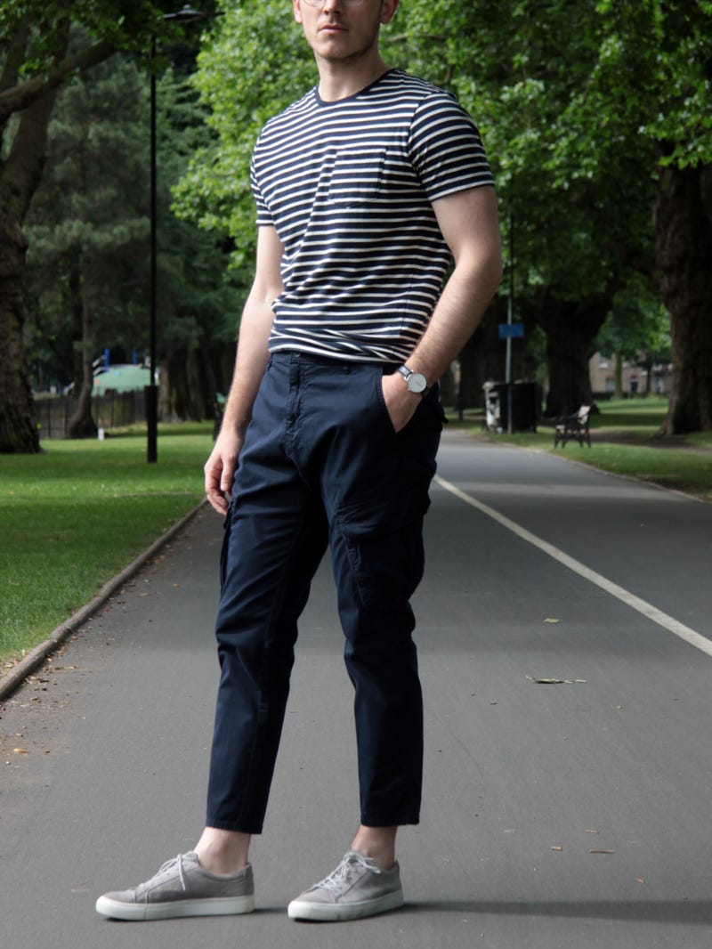 Men's outfit idea for 2022 with striped crew neck t-shirt, cargo pants, neutral sneakers. Suitable for summer.